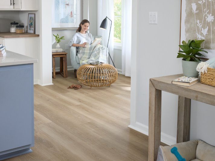 Woman reading in a cozy home with Pergo Elements flooring